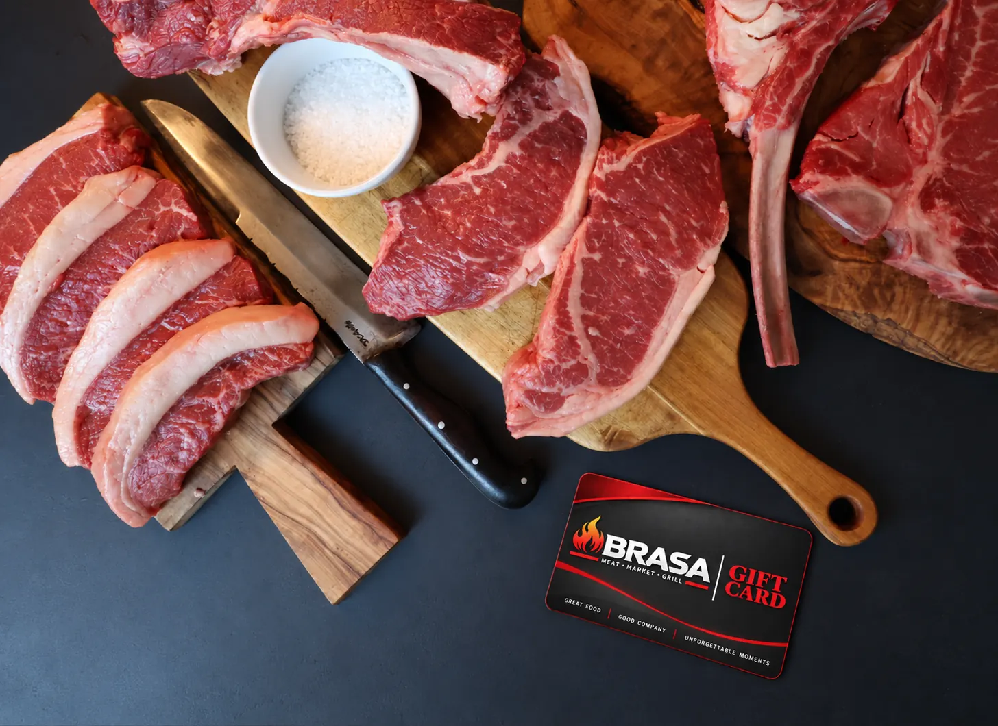 Brasa Gift Card displayed with premium butcher cuts on wooden boards