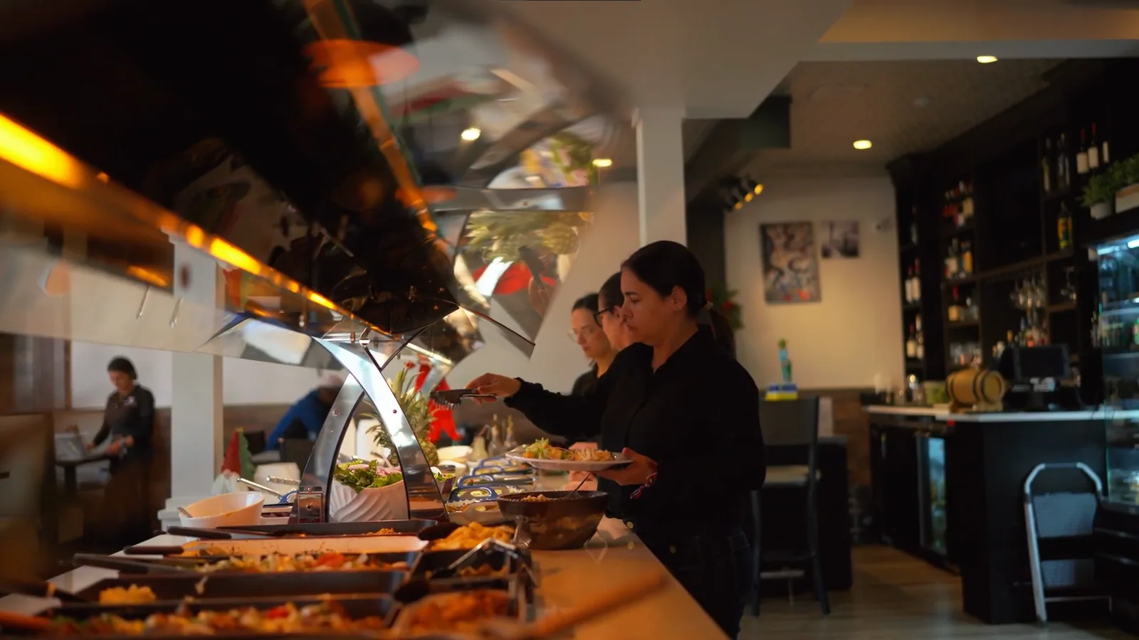Guests serving themselves from a fresh Brazilian buffet counter